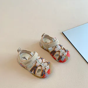 Close-up view of beige children's closed-toe sandals with colorful athletic details