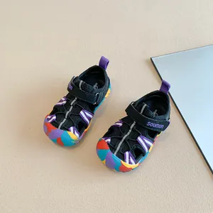 Top view of black children's sandals with colorful toe caps and purple accents