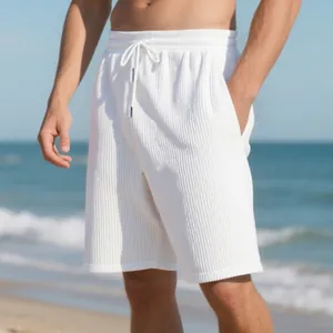 Close-up of white heavy jacquard beach shorts with drawstring on model at the beach