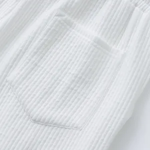 Close-up of white jacquard texture and pocket detail on men's summer beach shorts