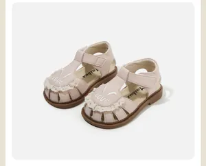 Vista detallada de sandalias rosas para niños con orejas de conejo y encaje suave