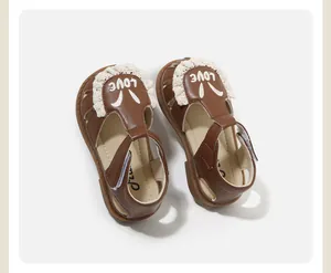 Vista superior de sandalias marrones de niña con encaje blanco y detalle de 'LOVE'