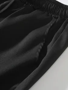 Dettaglio ravvicinato dell'elastico in vita e della tasca su pantaloncini neri uomo