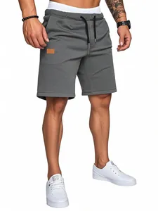 Vista inferiore dei pantaloncini grigi casual da uomo con coulisse e scarpe bianche