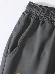 Dettaglio ravvicinato di pantaloncini cargo grigio scuro con vita elastica e tasca