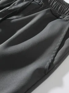 Dettaglio pantaloncini cargo grigi con vita elastica, coulisse e trama del tessuto