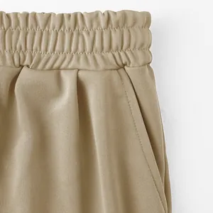 Nahaufnahme des bequemen elastischen Bunds und der Taschendetails an khakifarbenen Sportshorts.