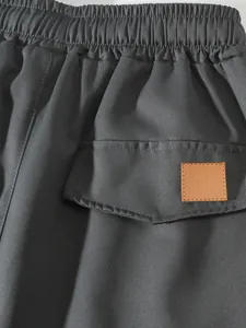 Dettaglio dei pantaloncini cargo grigio scuro da uomo con vita elastica e taschino.