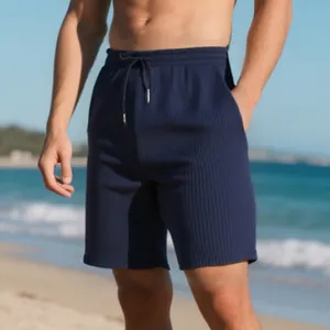 Detail view showing drawstring and textured ribbed fabric of men's navy blue beach shorts