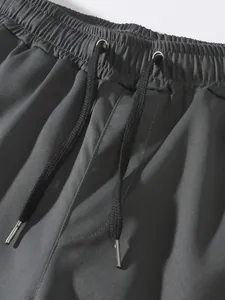 Dettaglio dei pantaloncini cargo da uomo con vita elastica e coulisse nera regolabile