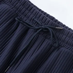 Close-up detail of navy blue ribbed fabric shorts featuring an elastic waistband and drawstring