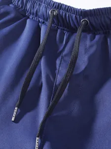 Dettaglio di pantaloncini cargo da uomo con vita elastica e coulisse nera regolabile