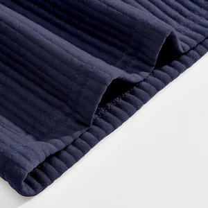 Close-up detail of heavy jacquard fabric and stitching on navy blue men's casual shorts