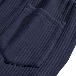 Close-up detail of navy blue ribbed fabric and pocket design on men's beach shorts