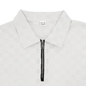 Close-up of white heavy checkerboard jacquard polo shirt with half-zip collar detail.
