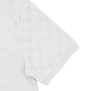 Macro view of heavyweight checkerboard jacquard texture on white short sleeve polo shirt