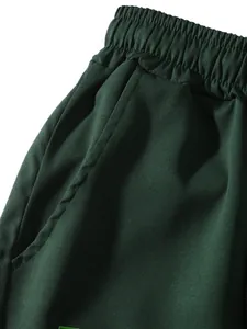 Dettaglio dell'elastico in vita e della tasca laterale dei pantaloncini cargo verde scuro