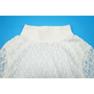 Dettaglio del pizzo floreale e del collo alto di questa elegante tutina corta.