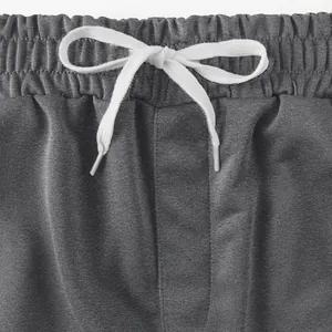 Detaillierte Nahaufnahme grauer Sportshorts mit weißem elastischem Kordelzug am Hosenbund