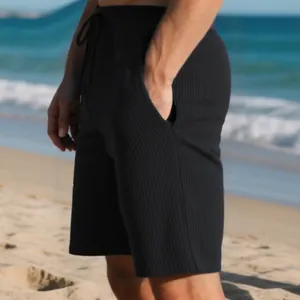 Close-up of black ribbed texture on men's relaxed fit summer beach shorts outdoors