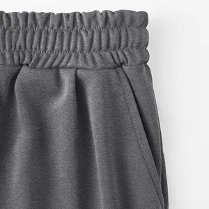 Detailaufnahme des elastischen Bunds und der Seitentasche der dunkelgrauen Sporthose.
