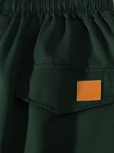 Primo piano della patta della tasca con toppa arancione su pantaloncini cargo verde scuro