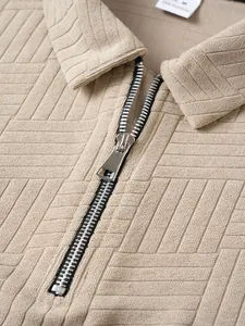 Detailed macro view of silver zipper and textured geometric pattern on beige polo shirt