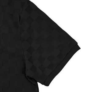 Close-up of heavy black checkerboard jacquard fabric on a men's polo shirt sleeve