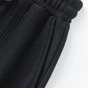 Close-up detail of heavy jacquard fabric and pocket on black men's casual sports shorts.