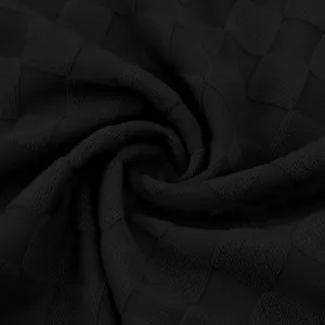 Detailed close-up of black heavyweight checkered jacquard fabric for casual men's polo shirts