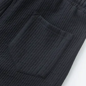 Close-up of black jacquard fabric and pocket on men's luxury casual beach shorts.