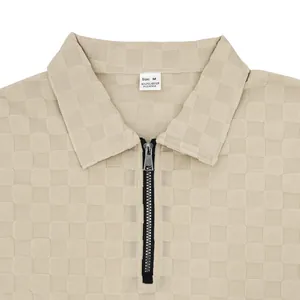 Detail of beige men's polo shirt with checkerboard jacquard and half-zip collar.