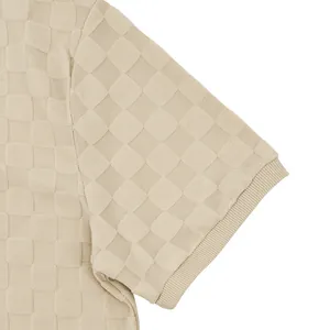 Close-up of beige checkerboard jacquard fabric and ribbed sleeve cuff on polo shirt