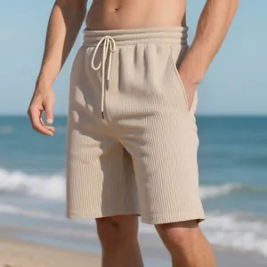 Men's beige heavyweight jacquard casual shorts shown in a natural summer beach setting
