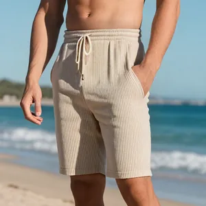 Detail shot of beige textured jacquard men's beach shorts with a drawstring waist