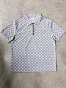 Macro view of grey checkered jacquard pattern on a men's half-zip polo shirt