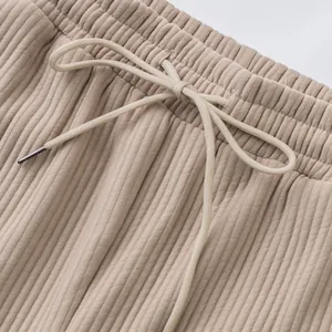 Close-up detail of beige jacquard textured waistband with adjustable drawstring cord.