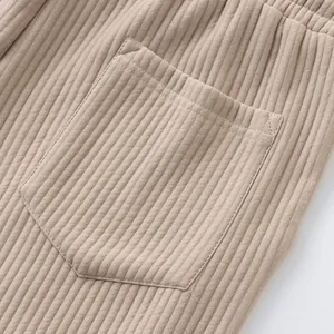 Macro view of the ribbed fabric texture and back pocket on beige men's casual shorts