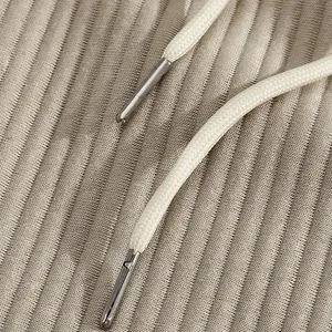 Close-up of drawstring with metal tips on textured jacquard fabric of men's beach shorts