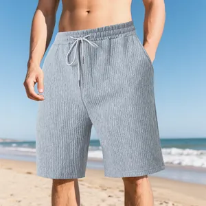 Detailed view of grey textured jacquard men's beach shorts worn on a sunny beach