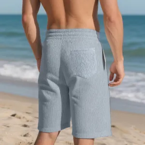 Detailed back view of men's grey jacquard beach shorts on a sunny beach
