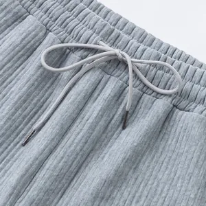 Macro detail of high-quality grey textured shorts showing elastic waistband and drawstring bow