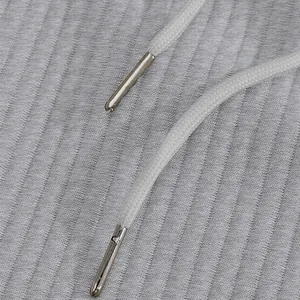 Close-up of premium white braided drawstring with metallic aglets on gray jacquard shorts