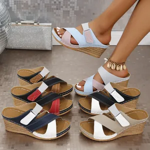 Detailed macro view of color-block wedge sandals featuring adjustable Velcro straps