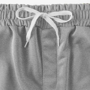 Detailansicht grauer Herren-Sportshorts mit elastischem Bund und weißem Kordelzug