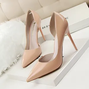 Elegant nude patent leather d'Orsay pumps with pointed toe and stiletto heels.