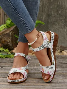 Primo piano di sandali con zeppa da donna con stampa floreale colorata e velcro