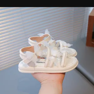 Vue détaillée de sandales blanches pour filles avec nœuds papillon et strass étincelants