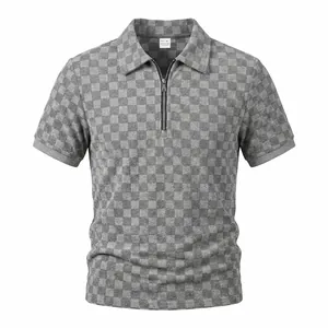 Vista dettagliata del motivo jacquard a scacchi grigi su una polo da uomo con mezza zip