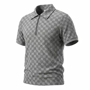 Dettaglio della trama jacquard a scacchi grigi sulla polo da uomo con mezza zip